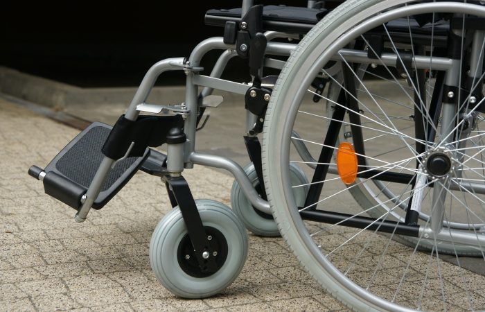 Side view of a silver-colored manual wheelchair, only the wheels are in view